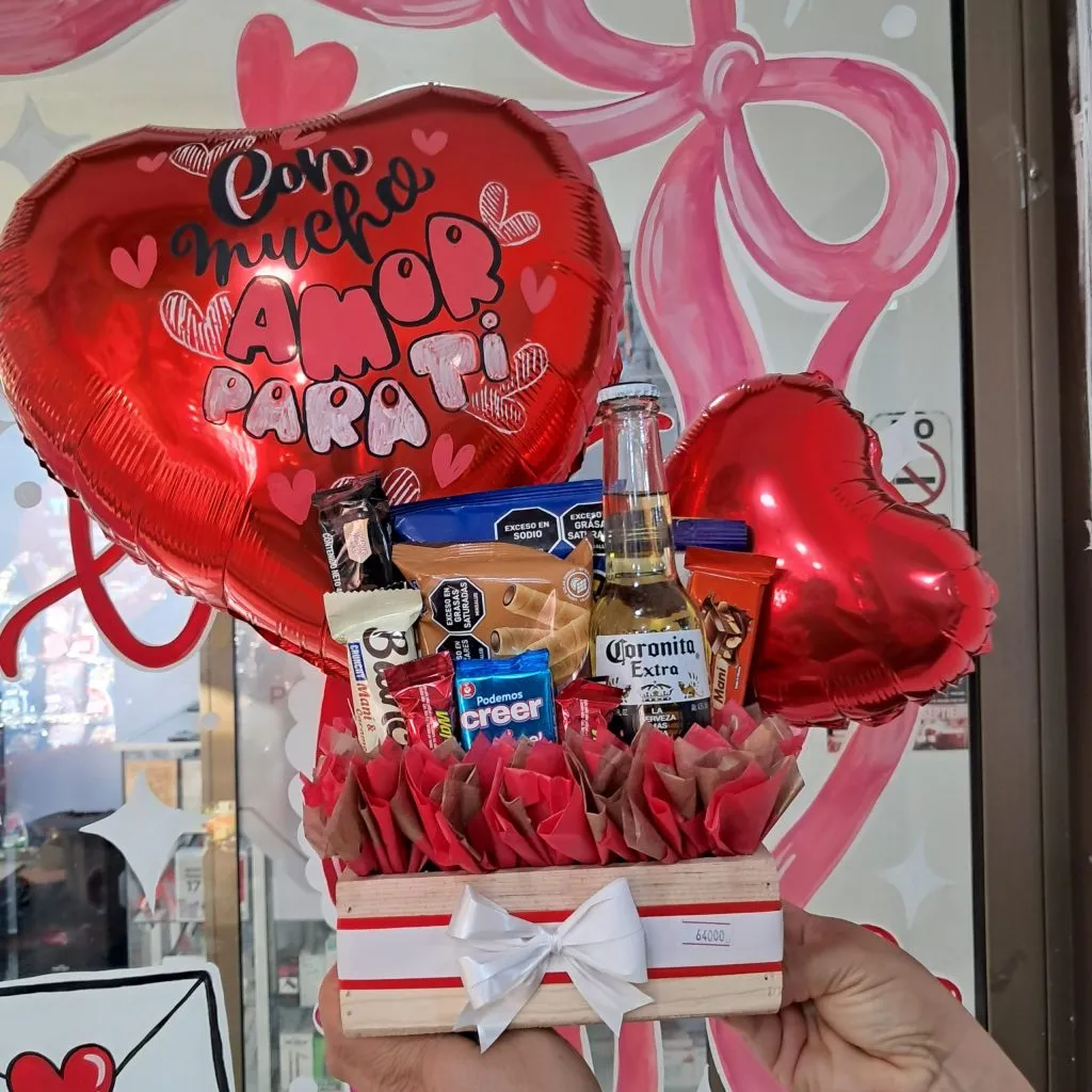 Ancheta de regalo con cerveza Coronita, dulces y globos corazón de amor exhibida en tienda Valeland Barbosa