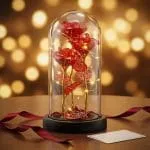 Cúpula con trío de rosas rojas translúcidas iluminada con luces LED cálidas en ambientación romántica de regalo