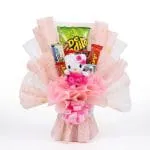Ramo ancheta estilo bouquet con peluche de Hello Kitty en vestido fucsia, chocolates, pasabocas y envoltura rosada sobre fondo blanco